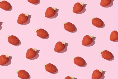 Sünger şekeri, çilek şekilli ve aromalı, yaratıcı yaz meyvesi deseni, pastel pembe arka plan.