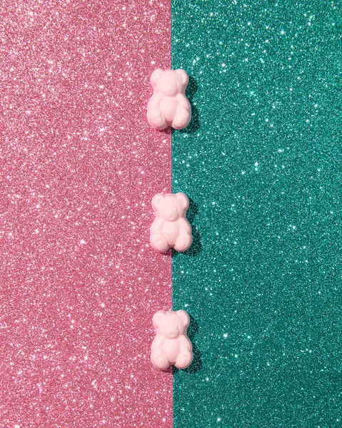 Three gummy bears against pink green glitter background, creative trendy layout.