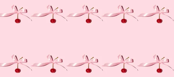新鲜的樱桃和缎带弓 创意浪漫的边框设计 粉红的背景 — 图库照片