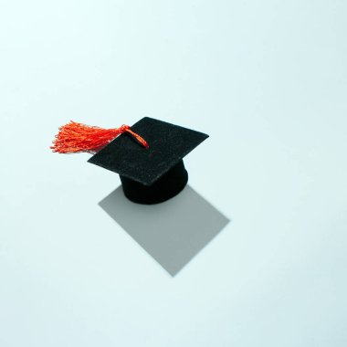 Mezuniyet şapkası ve pastel mavi arka plan diploması