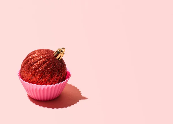 Kek olarak Noel süsü, yaratıcı kış tatili tebrik kartı, pastel pembe arka plan.. 