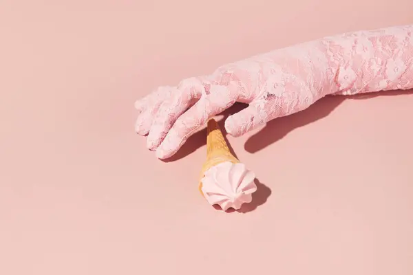 Pastel pink aesthetic composition, summer refreshment, ice cream and girl\'s hand in a lace glove.