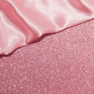 Parlak tozlu pembe arka plan, saten kumaş örtüsü, yaratıcı estetik düzen.