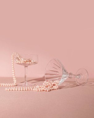 İnci boncuklu kokteyl bardakları, yaratıcı, estetik şampanya partisi kompozisyonu, pastel pembe arka plan..  