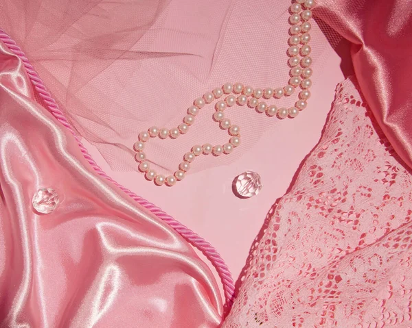 Kadınsı kumaş, tül, dantel, boncuk, pastel pembe yaratıcı arka plan kombinasyonu.