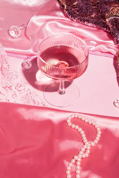 シャンパングラス 豪華なファブリック ビーズ クリスタル クリエイティブなパステルピンクの背景 ストック写真