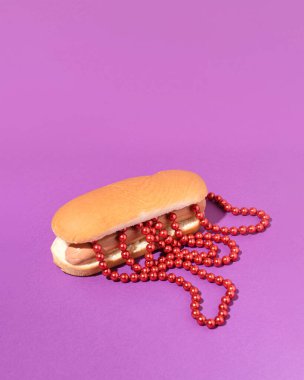 Ketçaplı sosisli sandviç, kırmızı inci boncuklu yaratıcı abur cubur konsepti.
