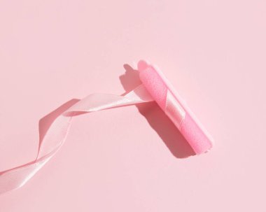 Sünger saç maşası, dalgalı saten kurdele, yaratıcı pastel pembe düzen, saç bakımı ve tasarım..