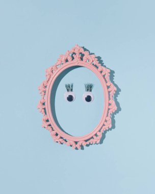 Gözler ve takma kirpikler, retro oval çerçevede minimum kadın yüzü, pastel mavi arka plan..