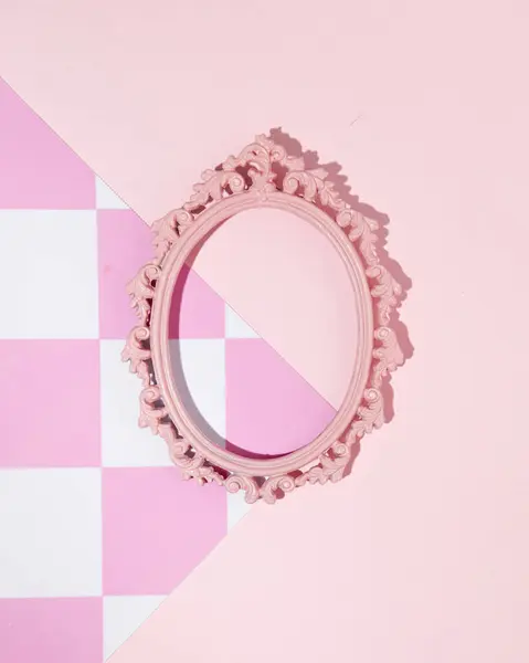 Vintage oval picture frame, pink checkered pattern background, retro style, 1950s nostalgia. Creative copy space.