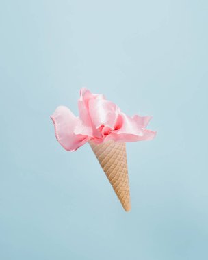 Dondurma külahı ve pembe ipek dekoratif çiçek, yaratıcı yaz arkaplanı, minimum konsept.