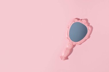 Bayanlar için klasik el aynası, minimum güzellik konsepti, pastel pembe arka plan, yaratıcı kopya alanı.