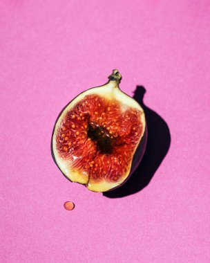 Tatlı olgun incir, bal sosu Neon pembe arka planda damlıyor.