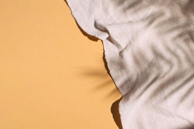 Klasik kenevir dokuma örtüsü üzerindeki tropik yaprak gölgeleri, çevre dostu kumaş, doğal kaba doku. Yaratıcı kopyalama alanı.