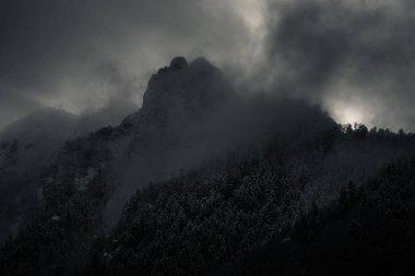 Dramatik bulutlu gökyüzü ile gizemli siyah dağ