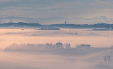 Sunrise in the mist in the Gers department in France with the Pyrenees in the background