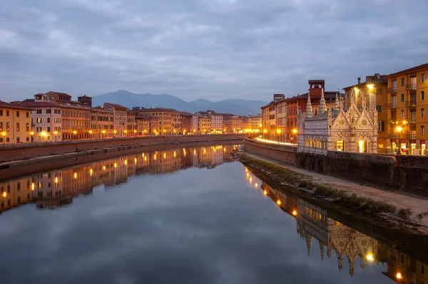 stock image The nightscape of the river Arno and Santa Maria della Spina in Pisa, Italy. Cloud reflection in the river, night city lights and mountains in the background