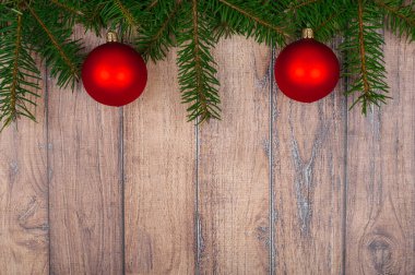 Yeşil ağaç dalları, kırmızı toplar ve yaylı Noel arkaplanı