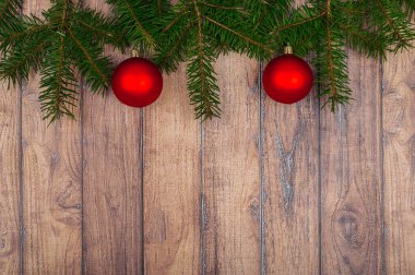 Yeşil ağaç dalları, kırmızı toplar ve yaylı Noel arkaplanı