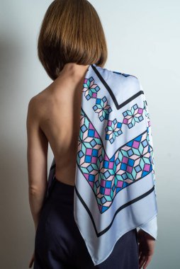 Moda kıyafetleri giyen güzel bir genç kadının portresi. Stüdyo çekimleri beyaz arkaplanda.
