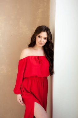 Uzun kırmızı elbiseli, güzel, gülen kadın şehvetli poz veriyor.