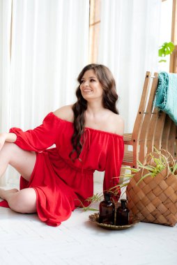 Uzun kırmızı elbiseli, güzel, gülen kadın şehvetli poz veriyor.