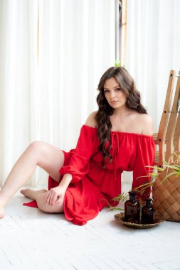 Uzun kırmızı elbiseli, güzel, gülen kadın şehvetli poz veriyor.