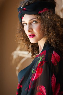 beautiful young woman in a red dress and a scarf on a black background