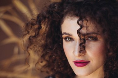 Kıvırcık saçlı güzel bir kadının portresi.