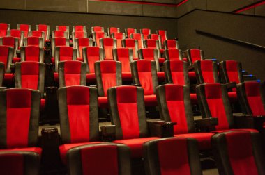 Kırmızı koltukları ve sandalyeleri olan boş sinema salonu.