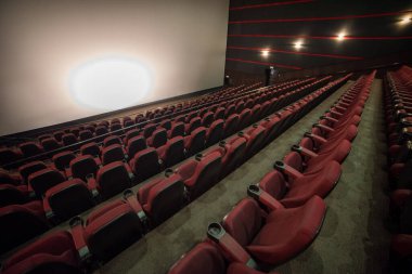 Kırmızı koltuklu ve geniş pencereli boş sinema.