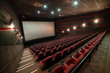 Kırmızı koltukları ve sandalyeleri olan boş sinema salonu.