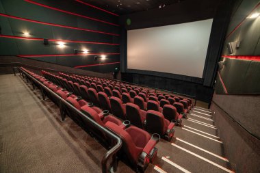 Kırmızı koltukları ve sandalyeleri olan boş sinema salonu.
