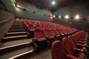 Kırmızı koltukları ve sandalyeleri olan boş bir tiyatro.