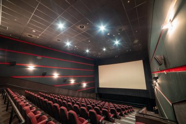 Kırmızı koltukları ve ışıkları olan boş sinema salonu.