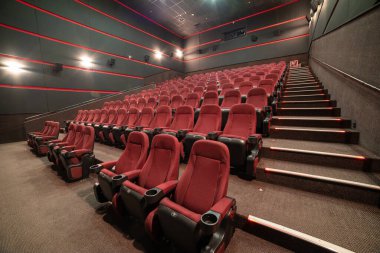 Kırmızı koltukları ve sandalyeleri olan boş sinema salonu.