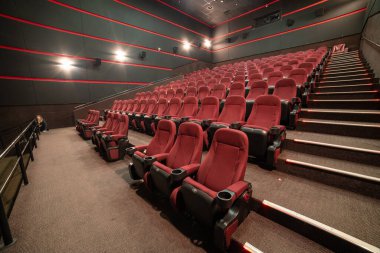 Kırmızı koltukları ve sandalyeleri olan boş sinema salonu.