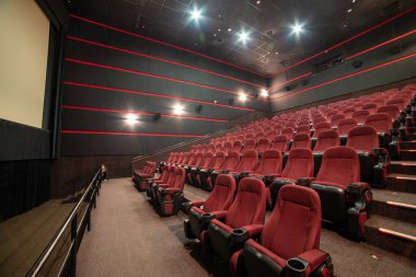 Kırmızı koltukları ve sandalyeleri olan boş sinema salonu.