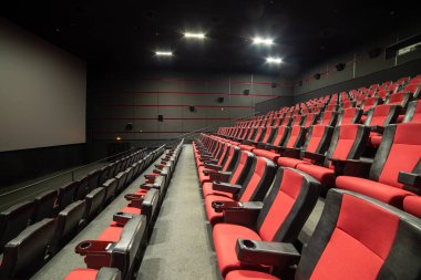 Kırmızı koltukları ve sandalyeleri olan boş bir salon.