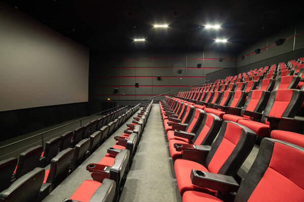 пустой зал открытого театра с красными сиденьями и большим окном