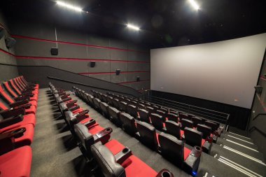 Kırmızı koltukları ve sandalyeleri olan boş sinema salonu.