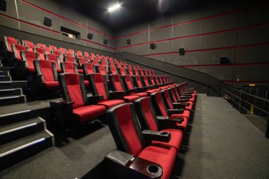Kırmızı koltukları ve sandalyeleri olan boş sinema salonu.