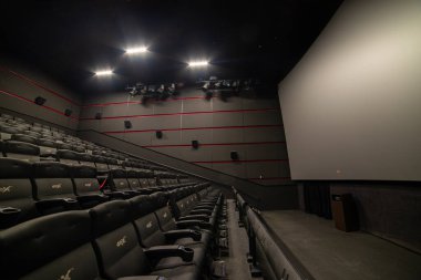 Kırmızı koltukları ve sandalyeleri olan boş sinema salonu.