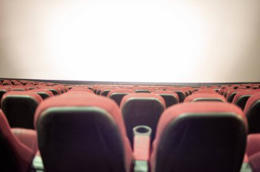 Kırmızı koltuklu ve geniş pencereli boş sinema.