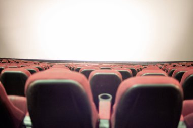 Kırmızı koltuklu ve geniş pencereli boş sinema.