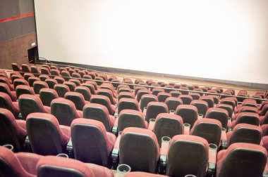 Kırmızı koltukları ve sandalyeleri olan boş sinema salonu.