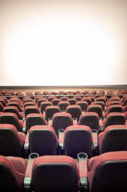 Kırmızı koltukları ve sandalyeleri olan boş sinema salonu.