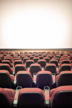 Kırmızı koltuklu ve geniş pencereli boş sinema.