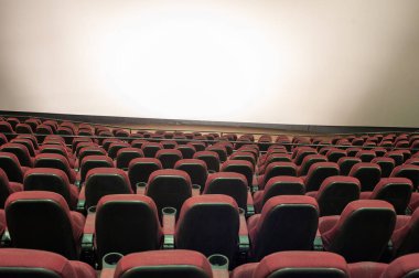 Kırmızı koltukları ve sandalyeleri olan boş sinema salonu.
