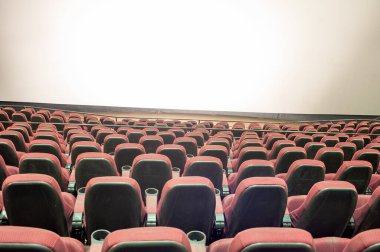 Kırmızı koltukları ve sandalyeleri olan boş sinema salonu.